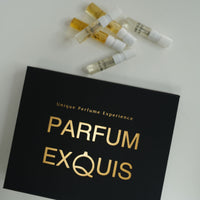 Black box with 'Parfum Exquis' branding and small perfume bottles on a white background